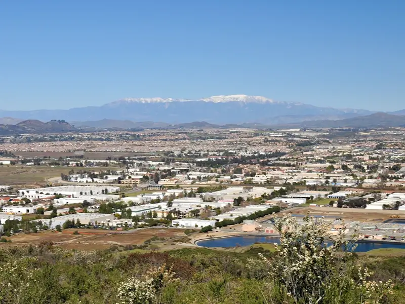 Cityscape with a snow-capped mountain in the distance.