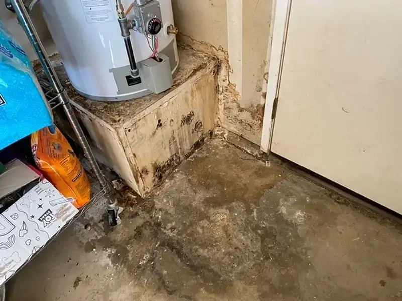 Water-damaged basement floor beside a water heater.