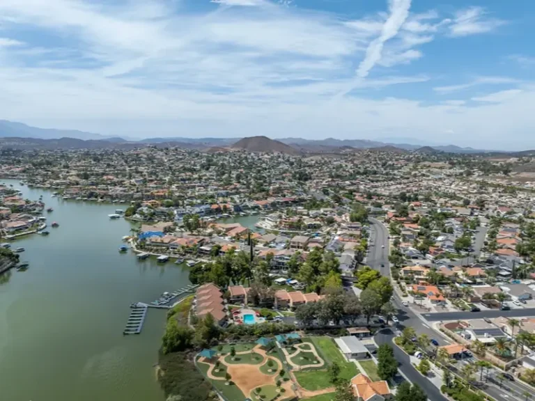 Aerial view of a lakeside suburban neighborhood with docks and hills.